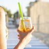 Persona tiene bicchiere con bevanda alla spiaggia.