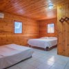 Interno di una stanza rivestita in legno, con due letti e un condizionatore.