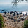 Spiaggia con ombrelloni chiusi.