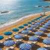 Ombrelloni blu sulla spiaggia, mare azzurro.