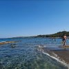 Spiaggia con mare limpido e bagnanti.
