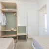 Stanza con due letti, armadio e camicia appesa.