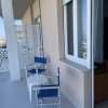 Balcone con sedie blu e grata decorativa.