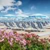 Ombrelloni e lettini a righe blu su una spiaggia.