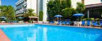 Piscina all'aperto con sedie blu e ombrelloni vicino a un hotel.
