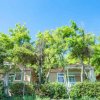 Bungalow tra alberi verdi e cielo azzurro.