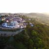 Vista aerea di un borgo in collina al tramonto.