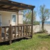 Casetta con veranda in legno affacciata sulla spiaggia sabbiosa.