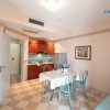 Cucina con tavolo apparecchiato, fiori al centro e quadro appeso al muro.