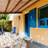 Tavolo apparecchiato all'aperto sotto un pergolato.