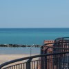 Balcone fronte mare con barca a vela in lontananza.