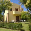 Casa gialla con giardino e alberi circostanti.