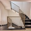 Scala moderna con ringhiere in metallo e luci a LED lungo le pareti.