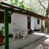 Casa bianca con patio e sedie in giardino.